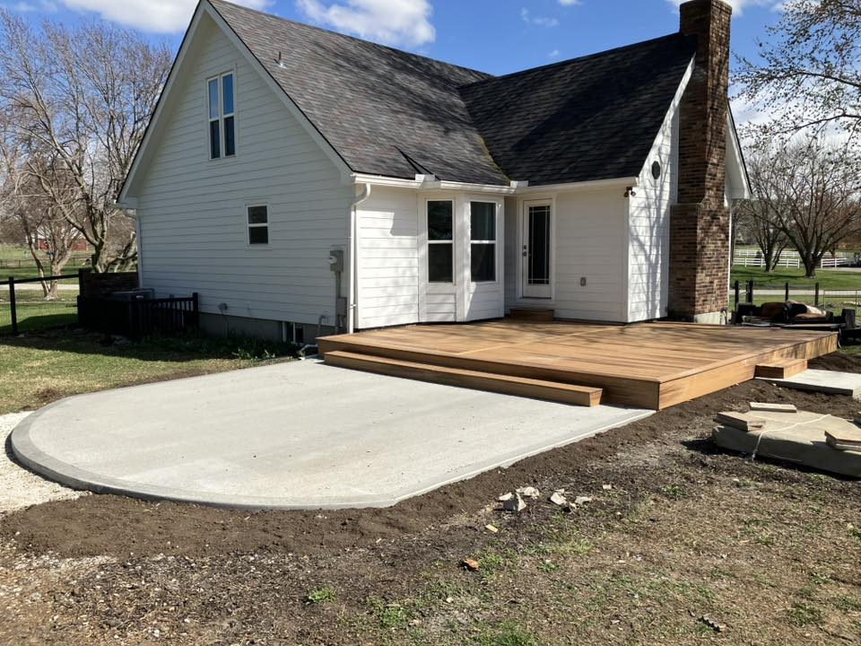 Deck and concrete patio addition on farmhouse style home