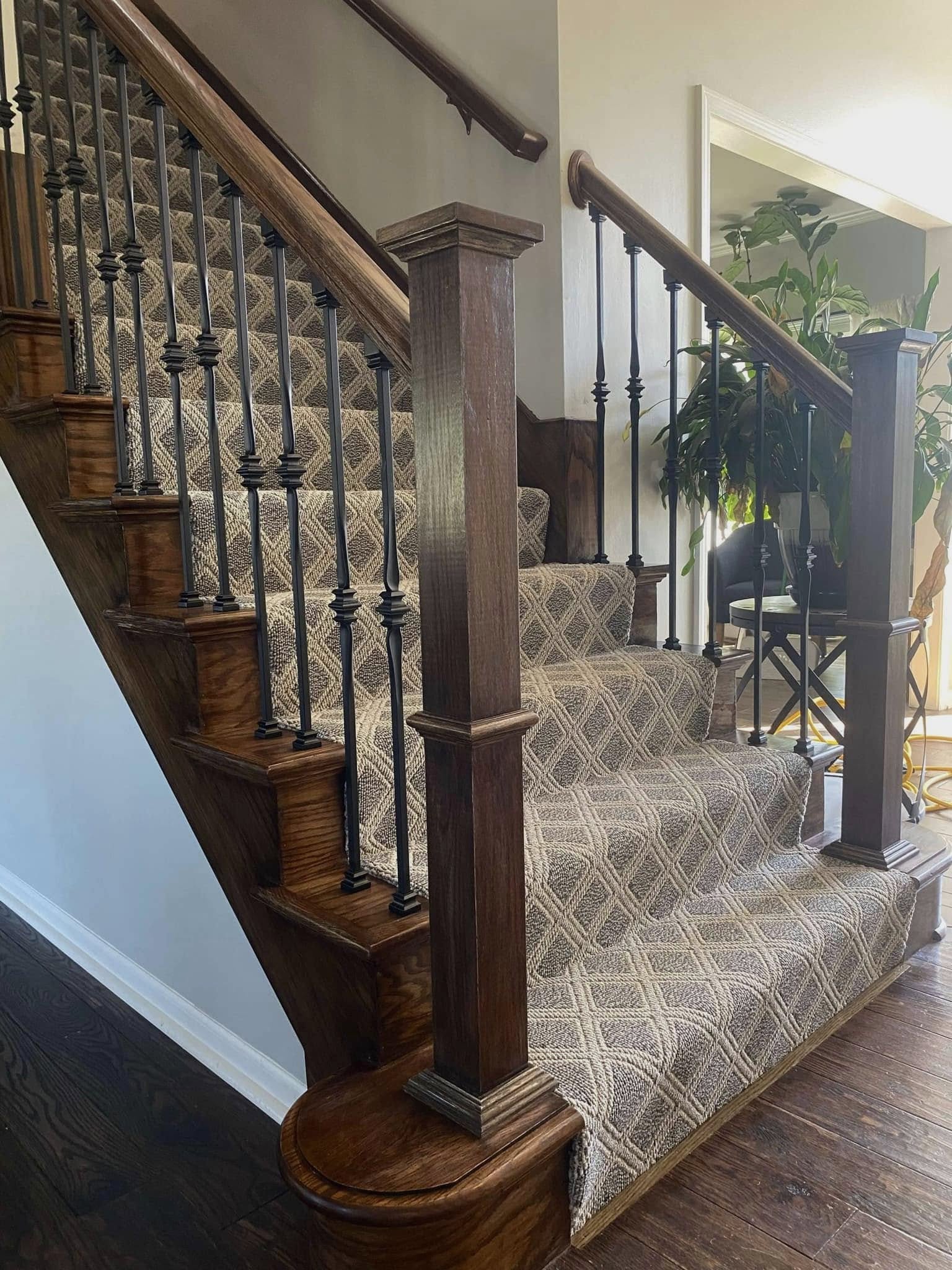 Custom wood staircase with wrought iron balusters and stained handrail