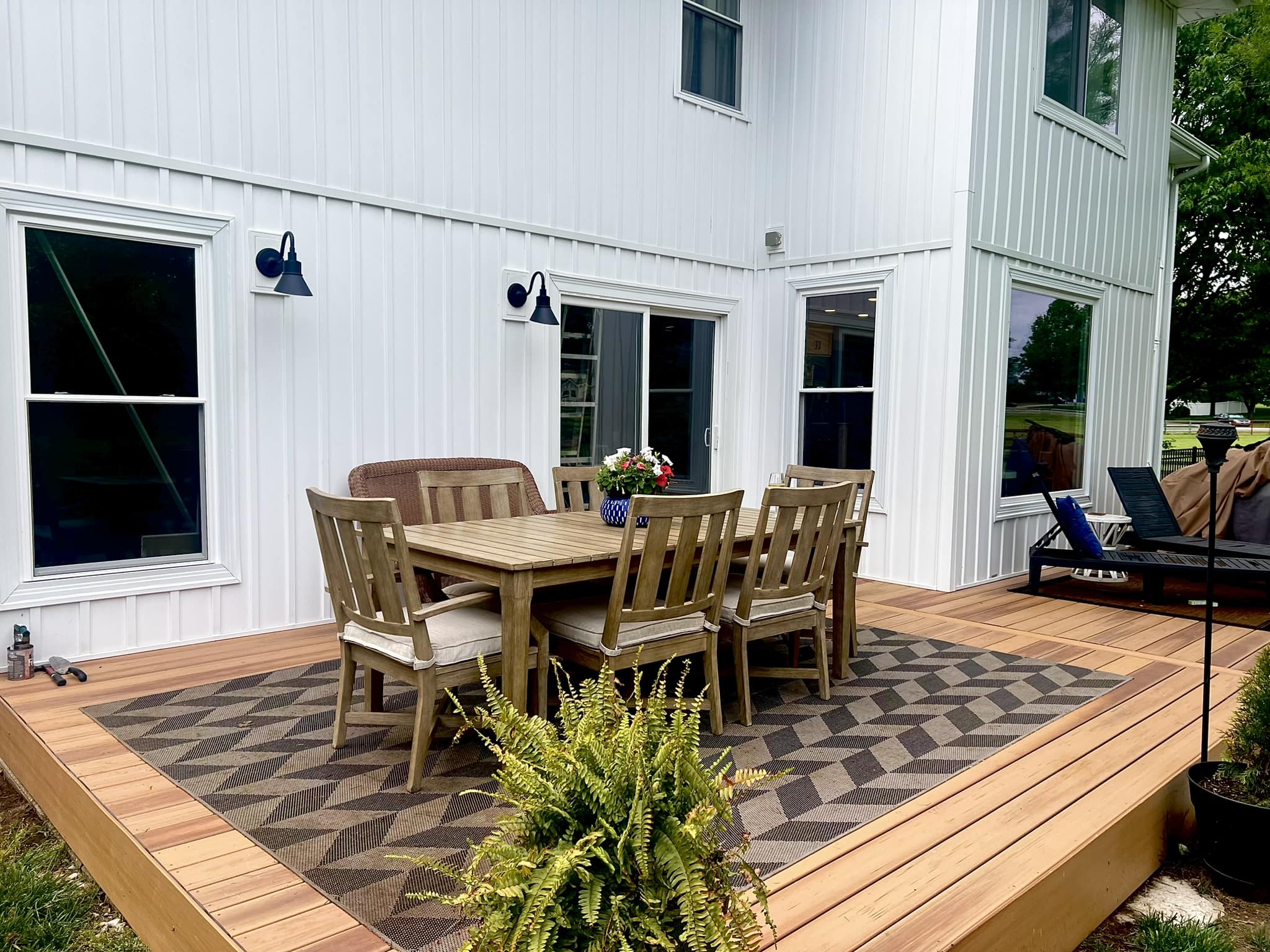 Composite deck with outdoor dining area on modern white farmhouse