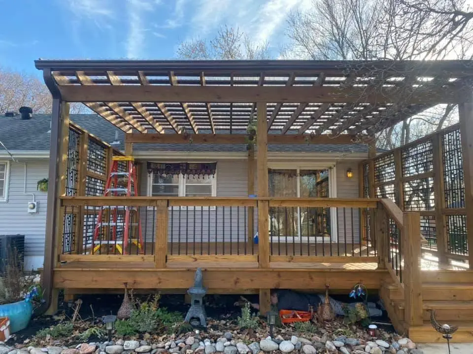 Completed cedar pergola with lattice privacy screens and deck railing