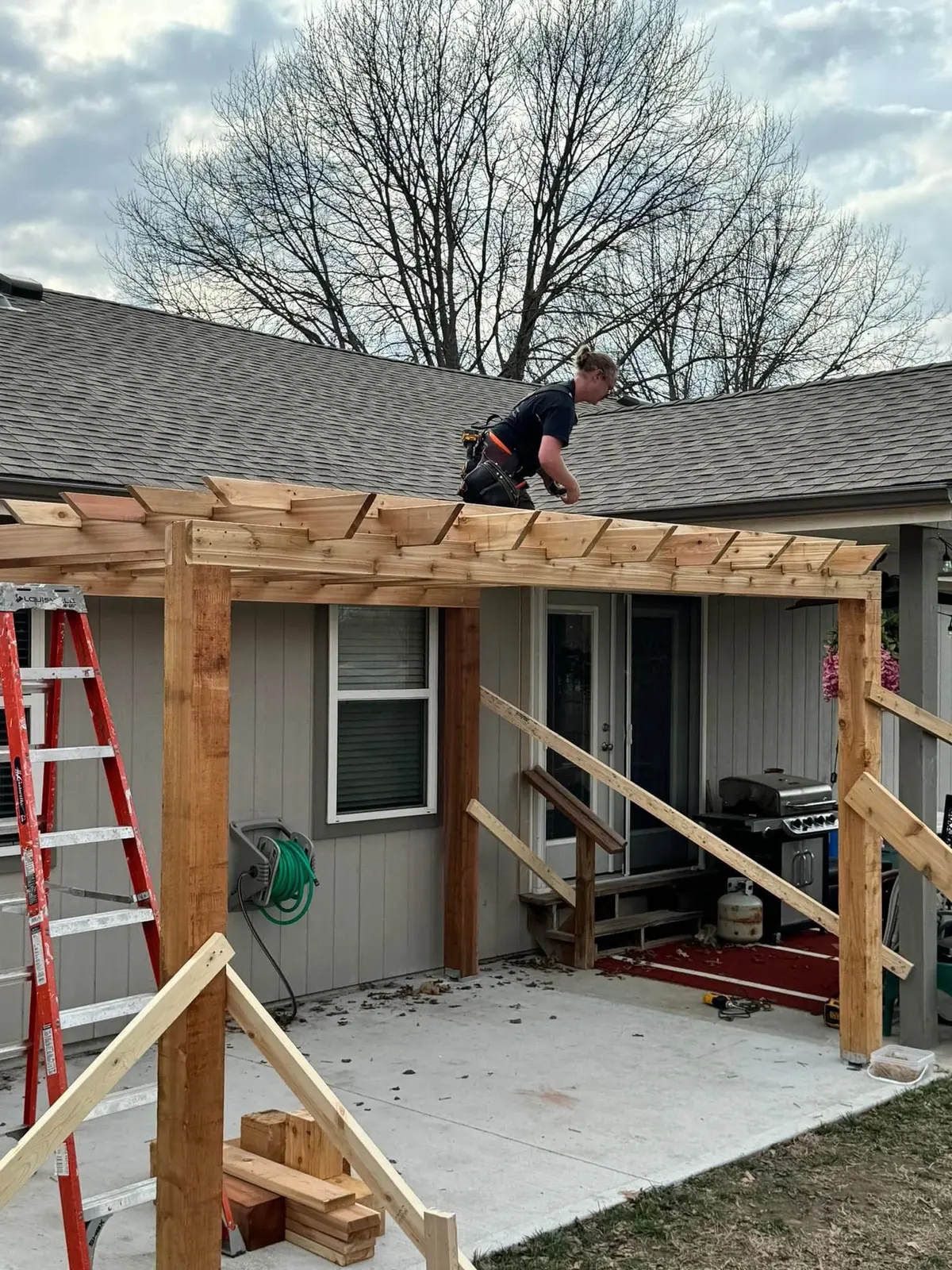 Cedar pergola construction in progress over back patio